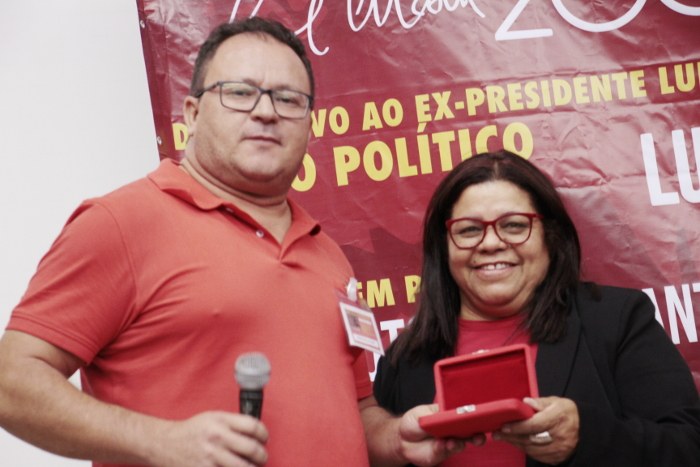 Prof. Adelmar (CLCN-GO) recebe de Jacqueline Alves a comenda Imprescindível a ser entregue a ........