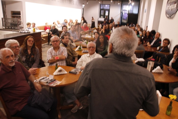 Prof. Vasconcelos, o jornalista Julio Cesar de Freixo Lobo e convidados ouvem o autor